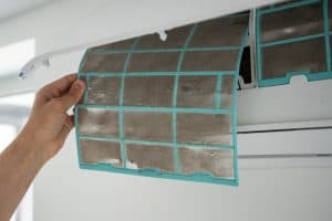 Replacing a dirty air filter during an AC Repair
